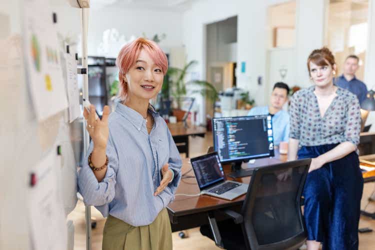 Entrepreneur explaining new marketing strategy to colleagues in office