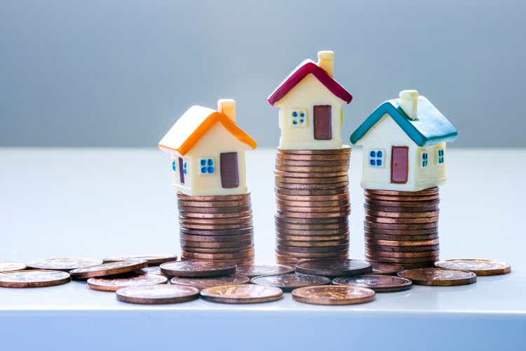 Houses on top of stacks of coins. Concepts: Mortgages, house market or Real Estate