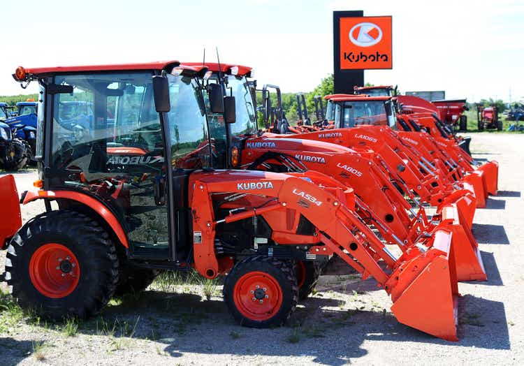 Kubota cab loader tractors lined up for sale at dealership