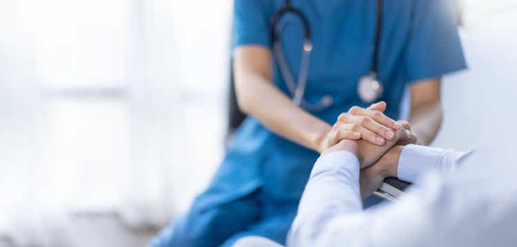 Cropped shot of a female nurse hold her senior patient"s hand. Giving Support. Doctor helping old patient with Alzheimer"s disease. Female carer holding hands of senior man