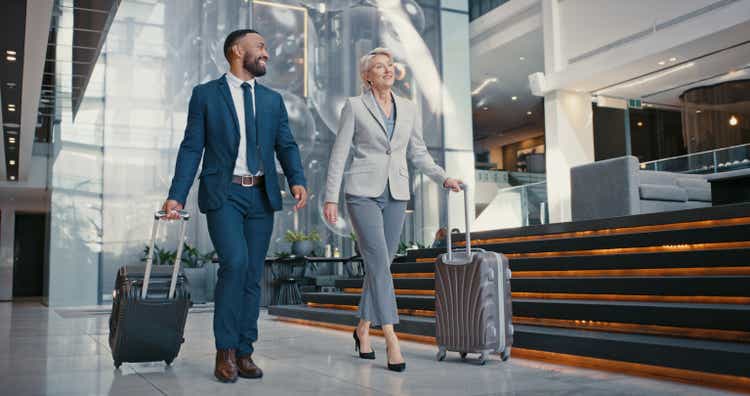 Travel, suitcase or business people in airport for conference, vacation or international work trip with manager. Employees, workers or corporate woman and man walking to airplane, hotel or workshop.