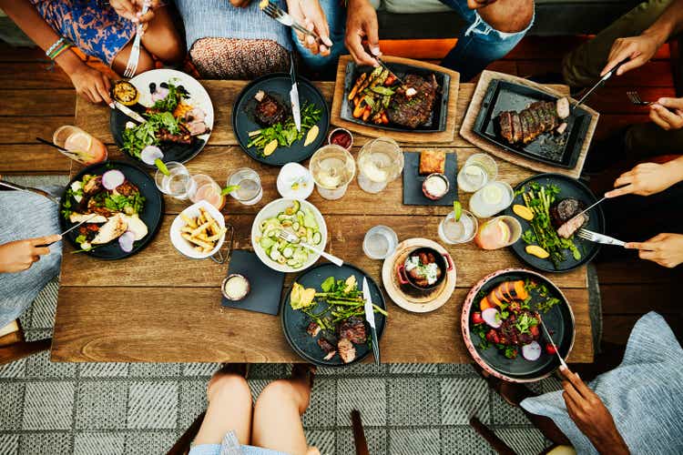 Medium overhead shot of families sharing dinner at outdoor restaurant