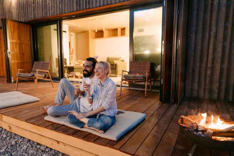 Young couple drinking wine by the fire pit