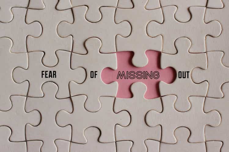 Top view image of puzzle with text FEAR OF MISSING OUT or FOMO.