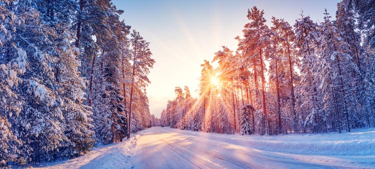 Beautiful view of the sunrise in the morning on the country snowy road.