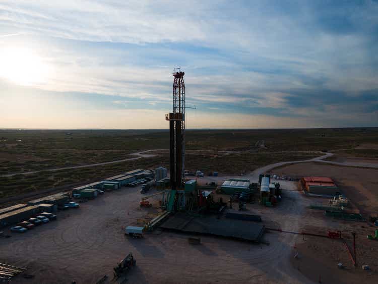 Sunset view of a Fracking oil rig under a dramatic sunset sky in the Permian Basin of West Texas or New Mexico