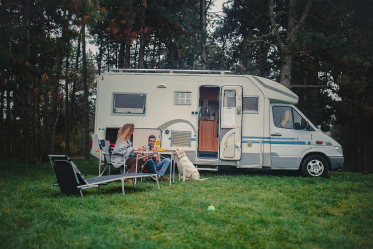 A loving couple and their dog camping in nature