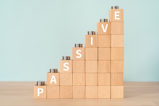 Wooden blocks with "PASSIVE" text of concept and coins.