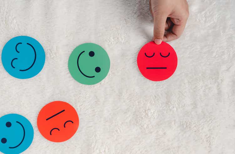Hand selected angry or sad face paper cut which is among various emotions, feedback rating , customer review, balance emotion control,mental health assessment, bipolar disorder unhappy of life concept
