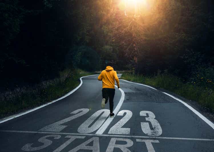Man running on the mountain road towards new goals in 2023. New Year 2023 with new ambitions, challenge, plans, goals and visions.