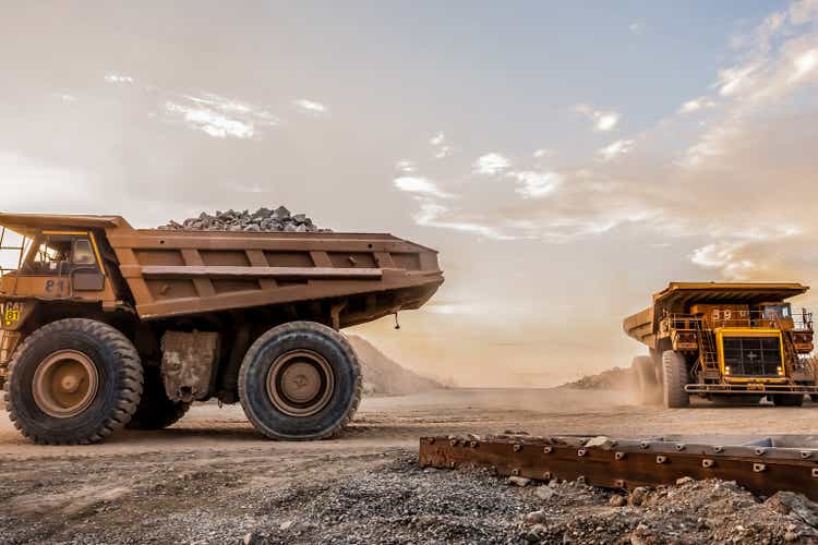 Trucks loaded with crushed rock fragments for transporting in platinum mining open pit, South Africa