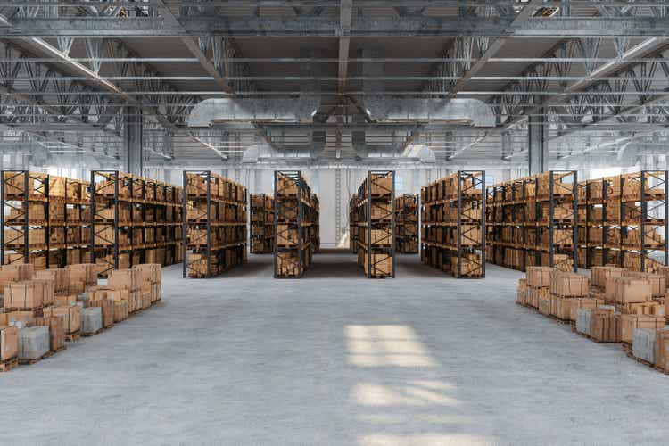 Distribution warehouse with cardboard boxes on shelves and floor