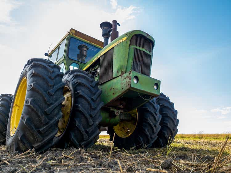 Big green John Deere tractor on a field during summer