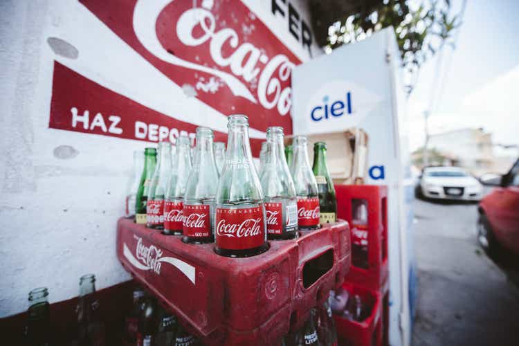 Set of half-empty Coca-Cola glass bottles in a red Coca-Cola box