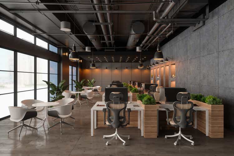 Interior Of Eco-Friendly Open Plan Office With Desks, Computers, Plants And Waiting Area