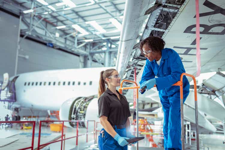Female apprentice aircraft maintenance engineers in aircraft maintenance hangar
