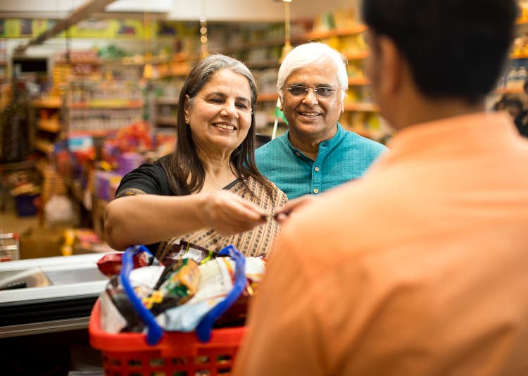 Senior couple paying at store counter