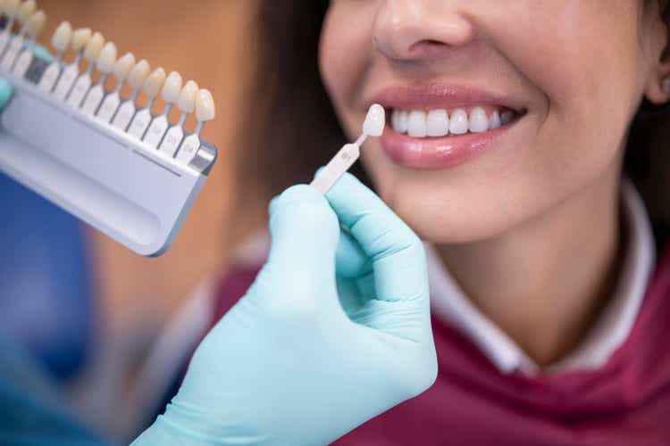 Dentist using tooth palette color samples.