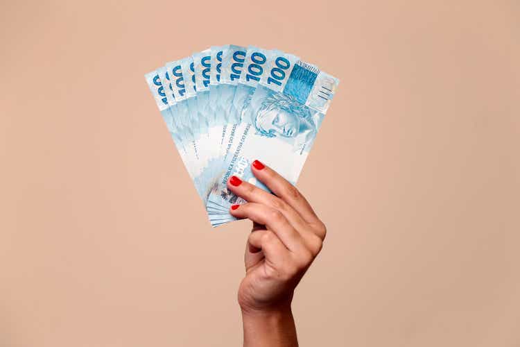 one hundred reais banknotes - hand holding brazilian banknotes