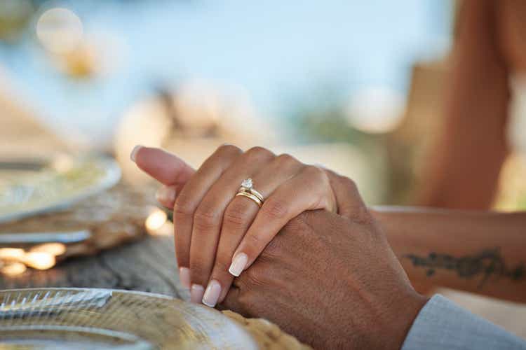 Bride with wedding ring holding hand of groom