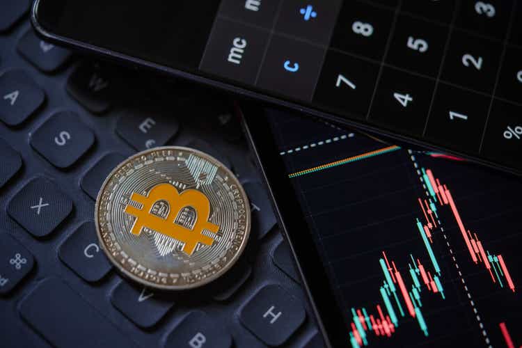 Bitcoin cryptocurrency with candle stick graph chart, laptop keyboard, and digital background