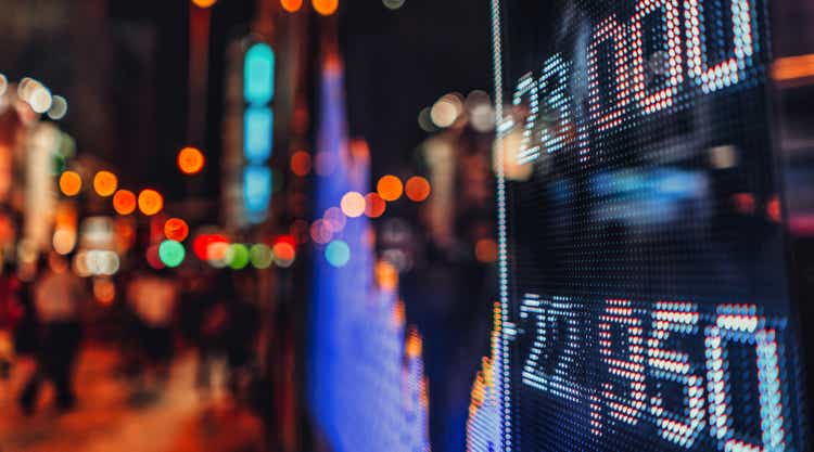 Stock market quote display with cityscape reflected in glass