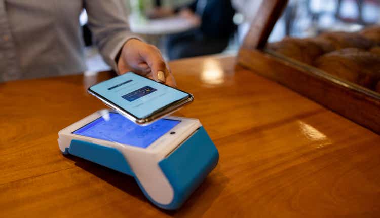 Close-up on a person making a mobile payment at a cafe