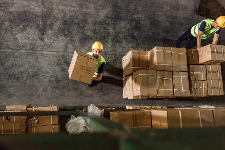 Above view of manual workers working in distribution warehouse.