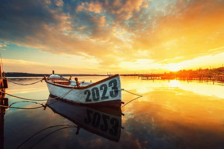 Концепция счастливого Нового года 2023 года. Рыбацкая лодка на варненском озере с отражением в воде на закате. Природный ландшафт.