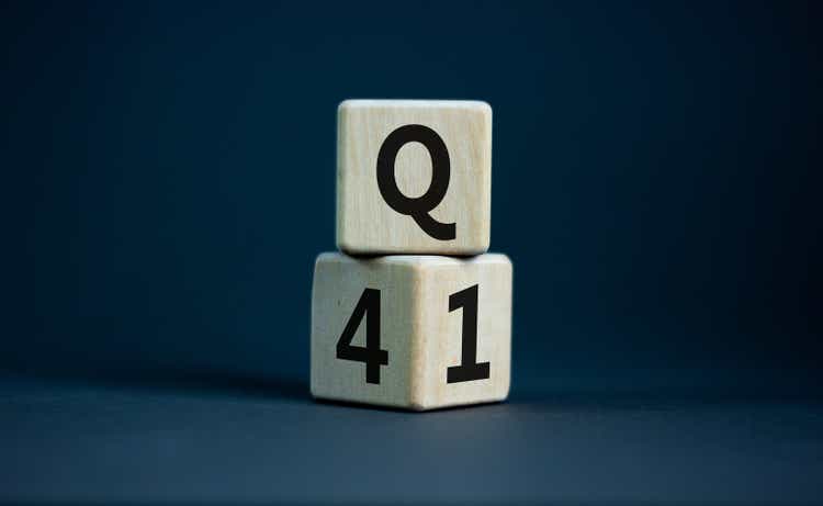 From 4th to 1st quarter symbol. Turned wooden cubes and changed words "Q4" to "Q1". Beautiful grey table, grey background. Business, happy 1st quarter Q1 concept, copy space.