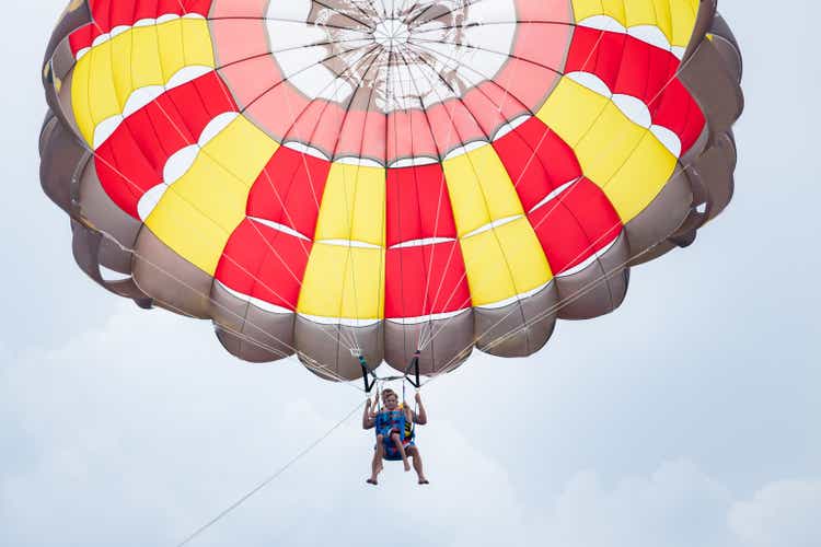 Father and son parasailing during summer day at sea