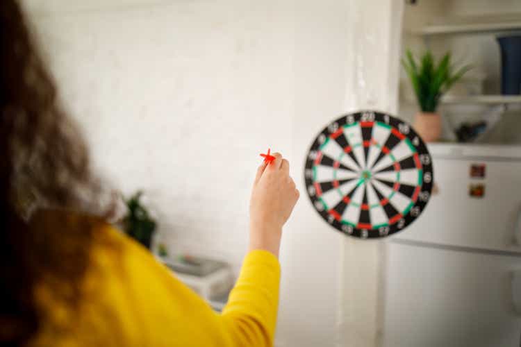 Modern young people are playing darts at home.