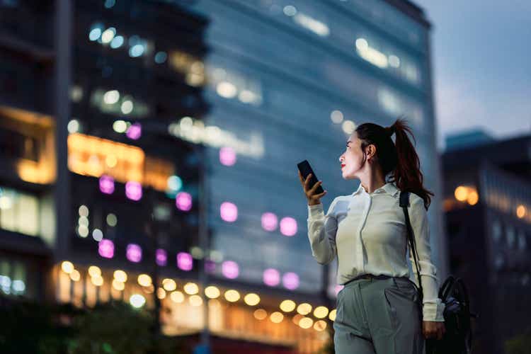Young businesswoman using smartphone in financial district,