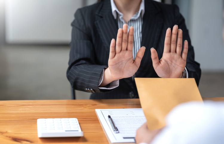 Authorities raising his hand refusing to accept bribes from customer.