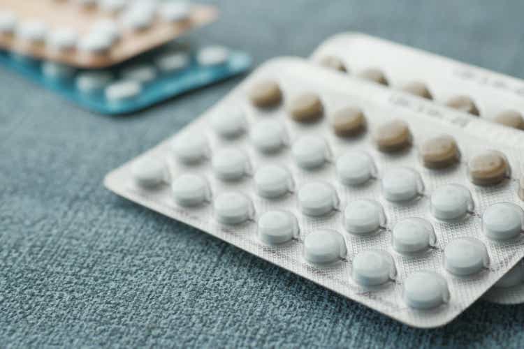 birth control pills on wooden background, close up