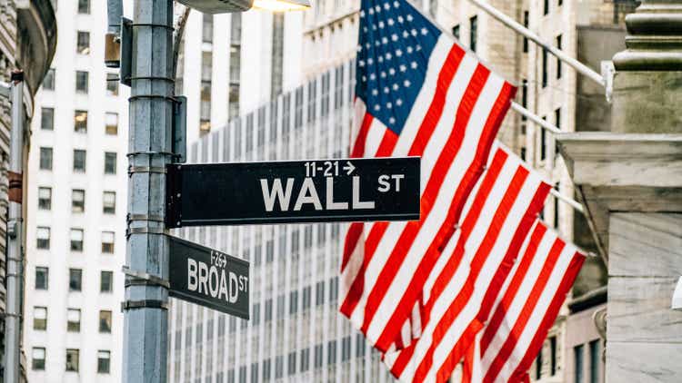 Wall street district in New York City with USA flags in the background