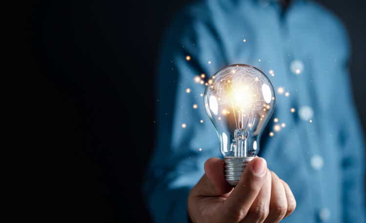 Innovate through creativity and inspired ideas. Human hand holding light bulb to illuminate, creative idea and sustainable business development inspiration concept.