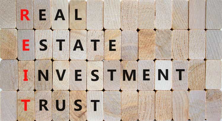 REIT real estate investment trust icon.  From REIT real estate investment trust concept on wooden blocks on beautiful wooden background.  Business REIT real estate investment trust concept.