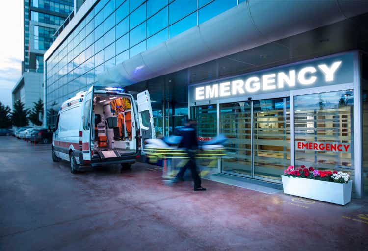 Paramedics transfer the patient on a stretcher from the ambulance to the hospital