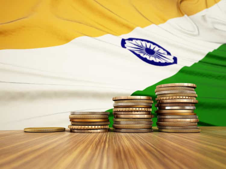 Rising stack of coins with Indian flag in the background. Economy, finance, interest rates concept