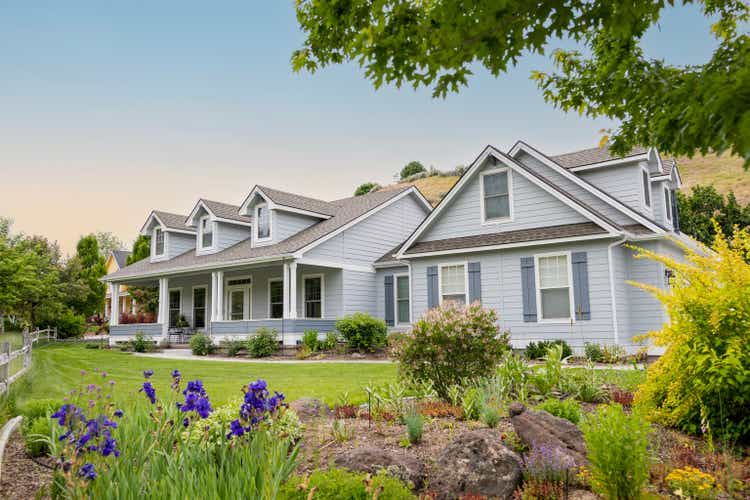 Suburban home at sunset with lawn and garden visible