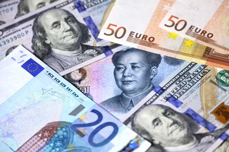 Chinese yuan surrounded with US dollars and Euro banknotes