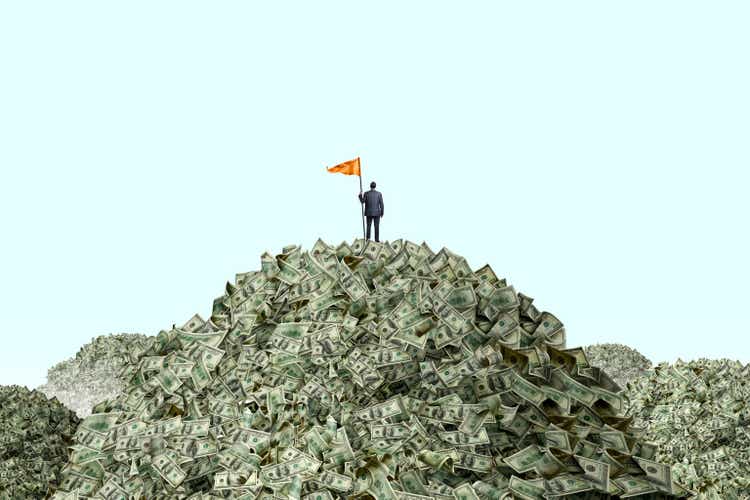 Man placing flag on stacks of cash