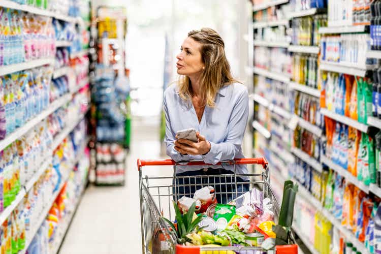 Mature woman customer purchasing grocery in supermarket