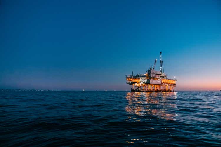 Low wide angle image of an offshore oil rig at dusk off the coast of Huntington Beach with copy space