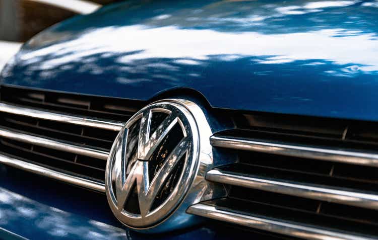 Closeup of a Volkswagen logo on the grille of a blue car