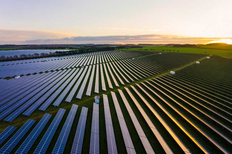 Abstract aerial/drone view over a field of solar panels at sunrise