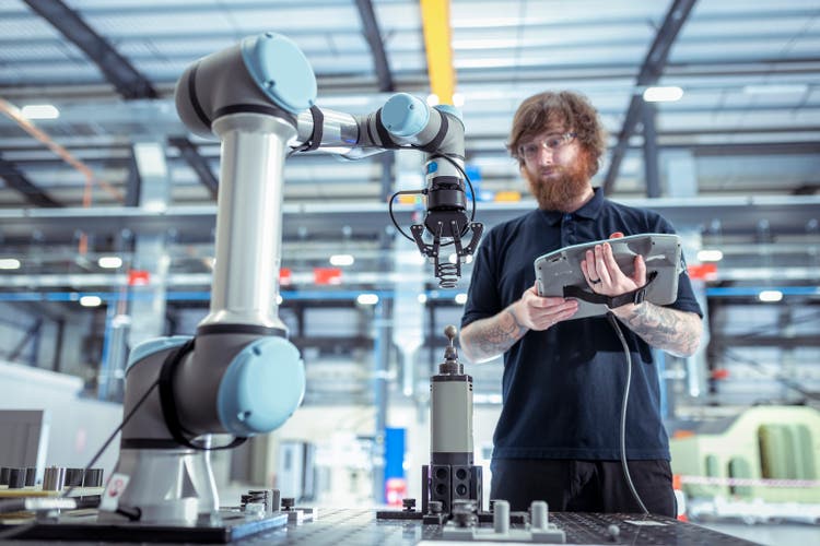 UK, Burnley, Operator with robot vehicle in battery research facility