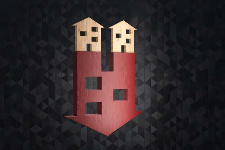 Wooden boards on a red down arrow having the shape of a house. Illustration of the concept of falling prices of house and real property crisis