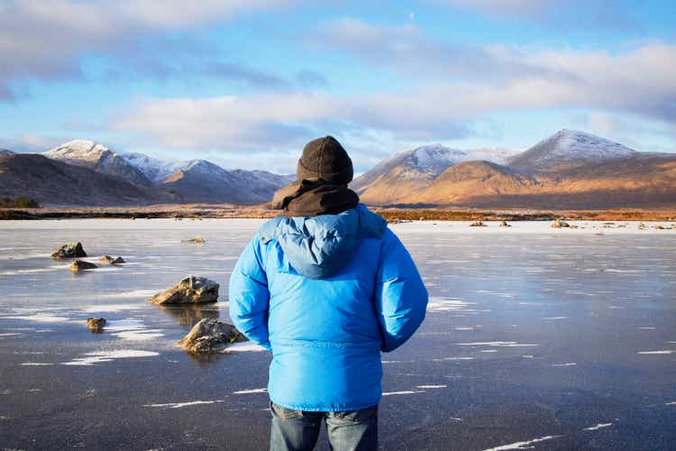 Man standing looking at Scottish Highlands winter landscape